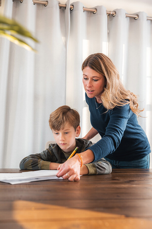Mother helping young boy with coursework