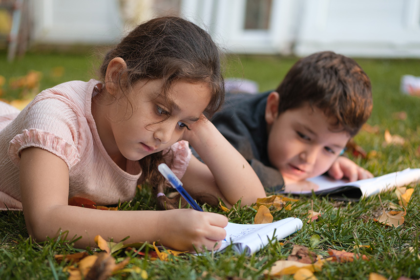 Two children doing homework outside