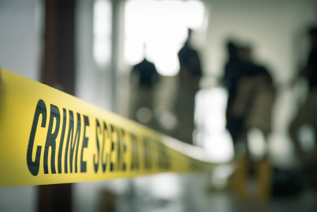 crime scene tape with blurred forensic law enforcement