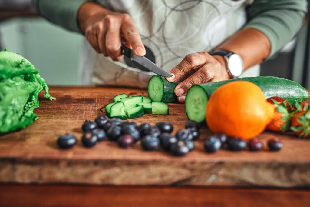 student cutting brightly colored vegetables