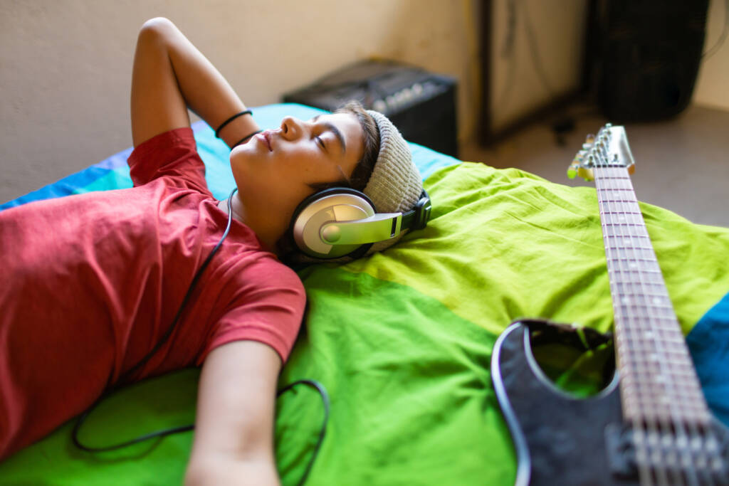 student listening to music calmly in his room