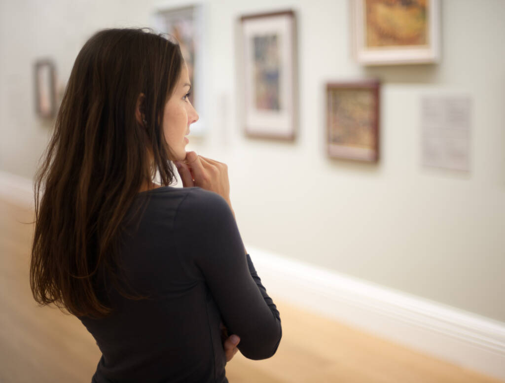 student looking at pictures in art gallery