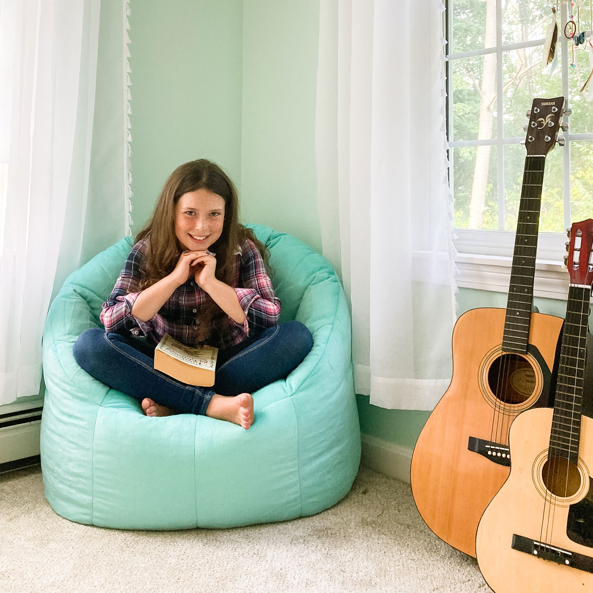 student-home-beanbag-chair-book-guitars student in her room reading on beanbag chair with guitars