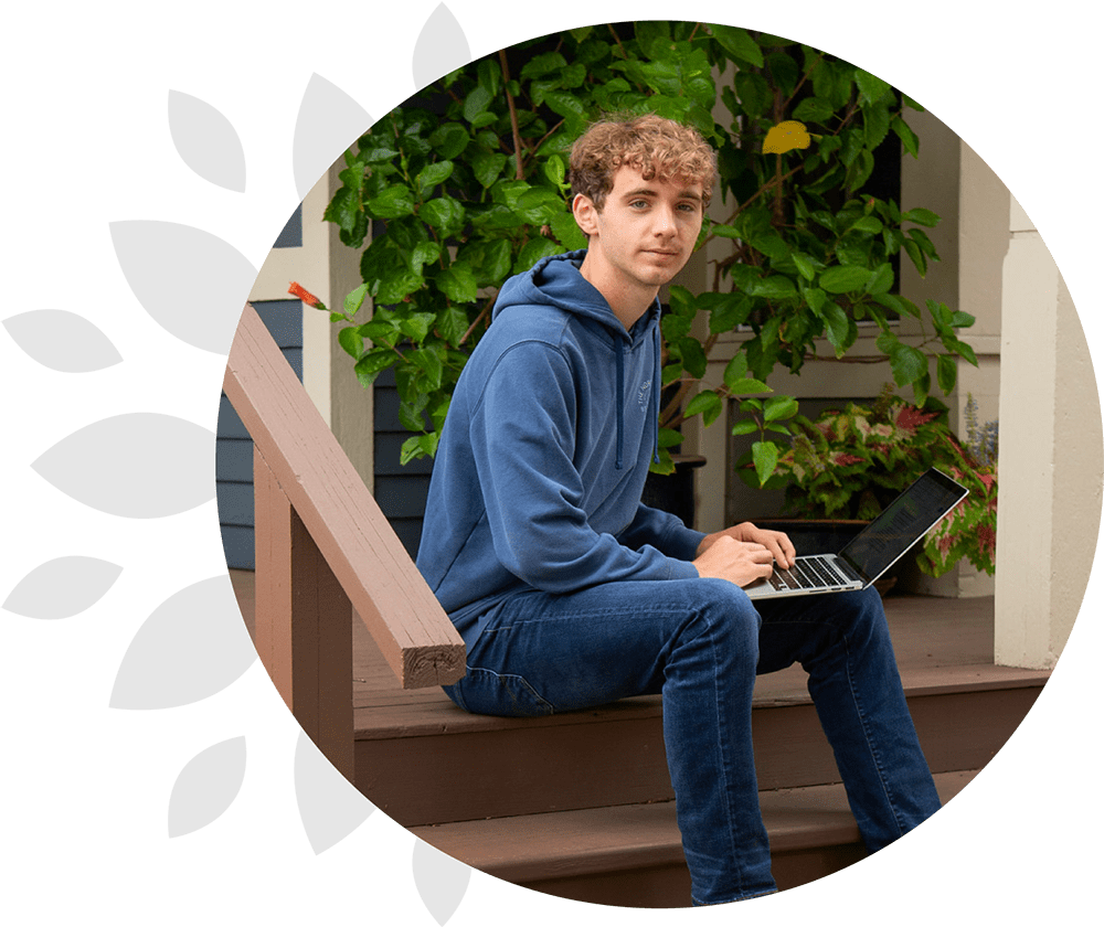 high school student with laptop on porch