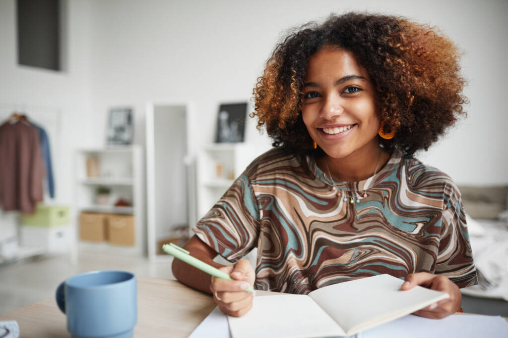 student studying at home and smiling at camera