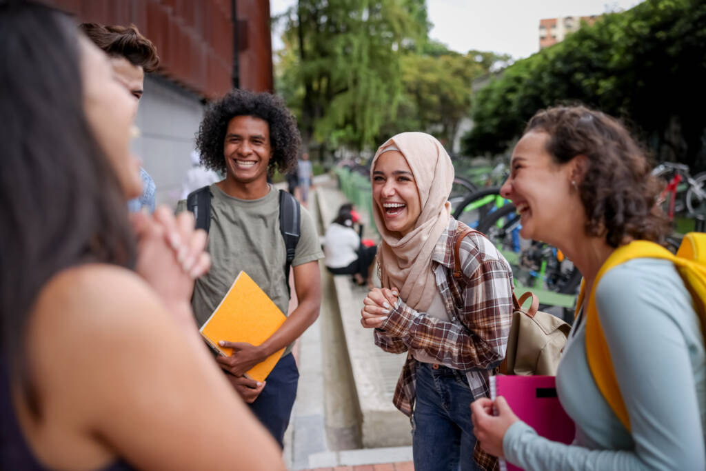 group of students looking very happy talking at the school and laughing