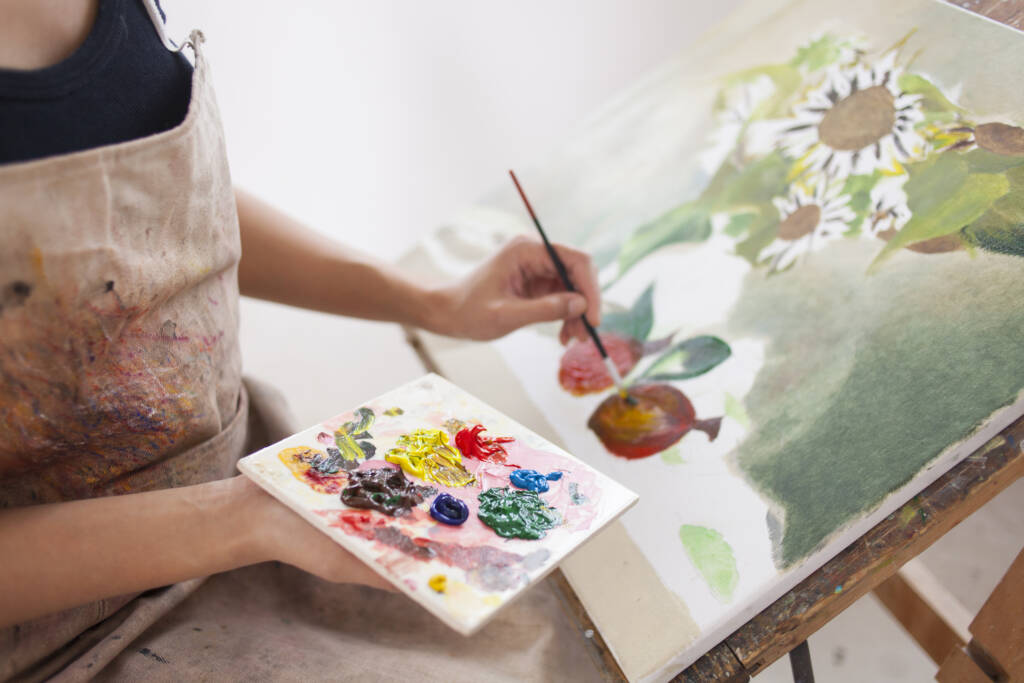 Female artist working in studio, drawing flowers.