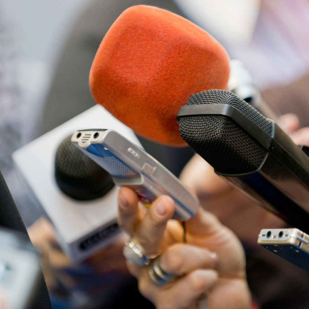 reporters microphones listening to interviewer